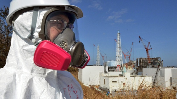 Besucher mit Atemmaske vor dem Kraftwerk Fukushima | Bild: Yoshikazu Tsuno, Pool/AP/dapd