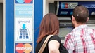 Menschen am Geldautomat einer Bank | Bild: picture-alliance/dpa
