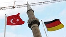 Eine türkische und eine deutsche Fahne wehen am 10.12.2009 in Kassel (Hessen) vor dem 34 Meter hohen Minarett einer im Bau befindlichen Moschee.  | Bild: picture-alliance/dpa