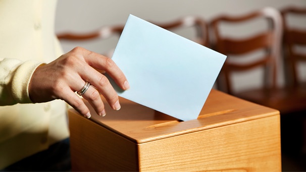 Frau wirft Umschlag in Wahlurne | Bild: colourbox.com