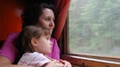 Frau mit Kind guckt während der Zugfahrt aus dem Fenster | Bild: colourbox.de