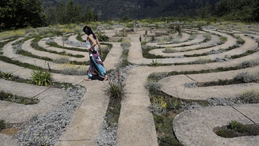 Eine Touristin geht durch eines der größten Labyrinthe in Hogsback, Südafrika | Bild: picture-alliance/dpa