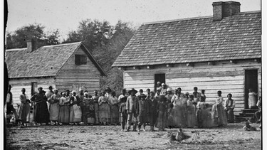 Sklaven vor ihren Unterkünften auf der Smith-Plantage in Beaufort, South Carolina. Fotographie von 1862 | Bild: picture-alliance/dpa