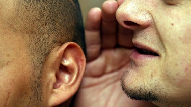 Mann flüstert anderem etwas ins Ohr | Bild: colourbox.com