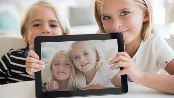 Schwester und Bruder zeigen Bild auf einem Tablet | Bild: picture-alliance/dpa
