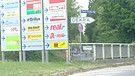 Wegweiser und Werbetafeln am Eingang zum Euro-Industriepark München  | Bild: BR/Miriam Garufo