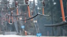 Die Bügel eines Schlepplifts hängen am 28.02.2016 in Sankt Englmar (Bayern) im Bayerischen Wald neben einer Skipiste mit wenig Schnee. | Bild: picture-alliance/dpa/Armin Weigel