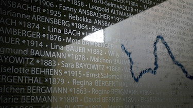Die Namen ermordeter Würzburger Juden sind im neuen Jüdischen Gemeinde- und Kulturzentrum in Würzburg auf einer Glastafel zu lesen.  | Bild: picture-alliance/dpa