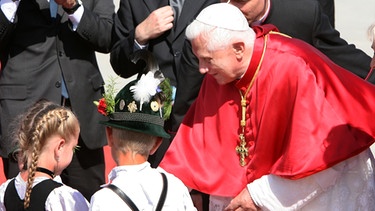 Papst Benedikt XVI. am 14.09.2006 auf dem Münchner Flughafen vor dem Rückflug nach Rom mit Kinder in Tracht | Bild: picture-alliance/dpa