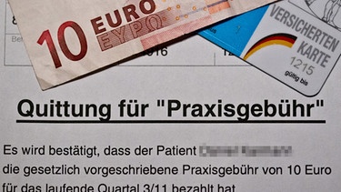 Ein Beleg über die Zahlung der Praxisgebühr liegt unter einem Zehn-Euro-Schein,  | Bild: picture-alliance/dpa