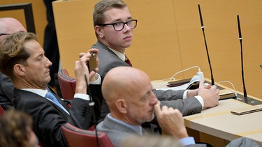 Daniel Halemba (M, AfD) sitzt am 31.10.23, einen Tag nach seiner Verhaftung, wieder in der Plenarsitzung des Bayerischen Landtags.
| Bild: BR Bild, Peter Kneffel/dpa