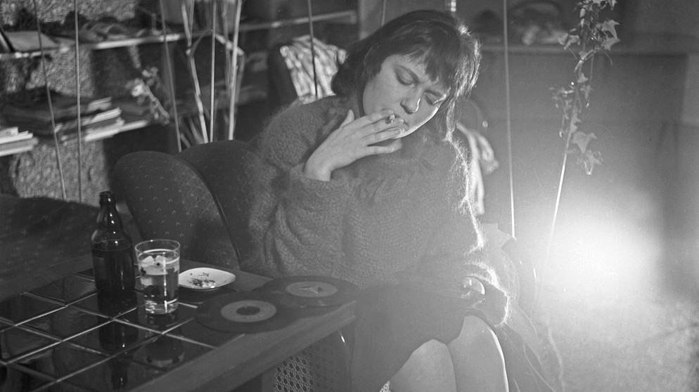 Eine Frau raucht und hört Vinyl | Bild: picture-alliance/dpa