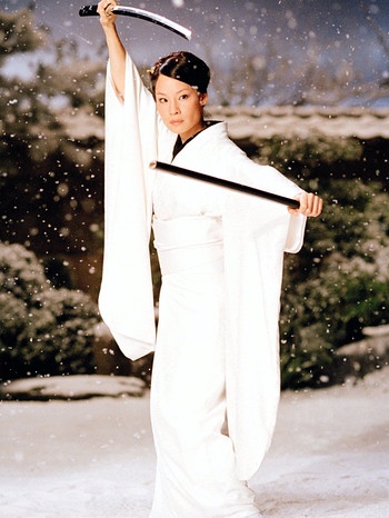 Man sieht Schauspielerin Lucy Liu in iher Rolle als O-Ren Ishi in dem Film Kill Bill aus dem Jahr 2001. Sie steht auf schneebedecktem Untergrund, trägt ein schneeweißes Gewand und hält mit erhobenen Händen einen Dolch hoch. | Bild: picture-alliance / dpa | dpa-Film Buena Vista