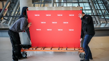 Zwei Menschen tragen einen Stellwand. Auf der rot bedruckenten Pressekonferenz-Stellwand ist das Logo "Die Linke" zu lesen. Die Linke-Bundestagsfraktion wurde am 6.12.2023 aufgelöst.  | Bild: picture alliance/dpa | Kay Nietfeld