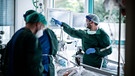 Krankenhauspersonal behandelt einen Patienten | Bild: dpa-Bildfunk/Fabian Strauch