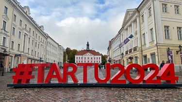 Estland, Tartu: Ein Schriftzug "#Tartu2024" ist in Großbuchstaben auf dem Rathausplatz aufgestellt. | Bild: dpa-Bildfunk