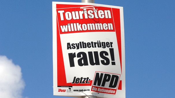 Wahlplakat der NPD mit der Aufschrift "Touristen willkommen - Asylbetrüger raus!" | Bild: picture-alliance/dpa 