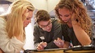 Drei Jugendliche arbeiten an einem iPad. | Bild: WDR/Langer