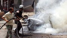 Weißhelme in Syrien löschen ein brennendes Auto | Bild: picture-alliance/dpa