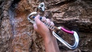 Ein Sicherungskarabiner wird in eine in den Felsen gebohrte Öse gehängt.  | Bild: picture-alliance/dpa