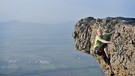 Ein Mann klettert an einem Felsen | Bild: picture-alliance/dpa
