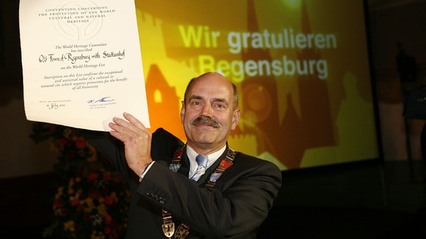 Oberbürgermeister Hans Schaidinge rhält die UNESCO-Welterbe-Urkunde hoch | Bild: Stadtbildstelle Regensburg