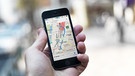 Jemand hält ein Handy mit einem Google-Maps-Stadtplan auf dem Display in der Hand. | Bild: mauritius-images