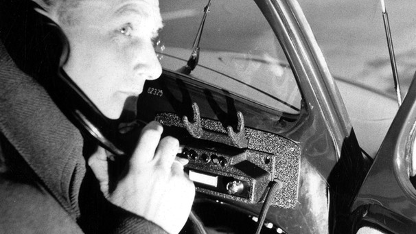 Ein Autofahrer benutzt im Januar 1955 die Sprechfunkanlage seines Autos.  | Bild: picture-alliance/dpa