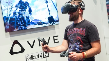 Besucher der GamesCom 2017 spielt mit der VR-Brille HTC Vive das Spiel Fallout VR | Bild: Messe Köln