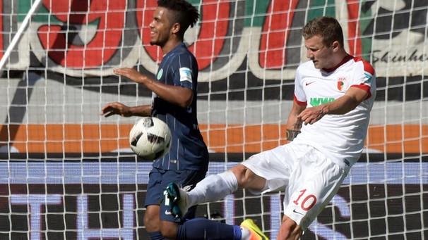 Augsburgs Daniel Baier (r) schlägt den Ball, nachdem Daniel Didavi von Wolfsburg das Tor traf. | Bild: dpa-Bildfunk