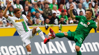  Der Mönchengladbacher Thorgan Hazard (l) und der Augsburger Dominik Kohr kämpfen um den Ball. | Bild: dpa-Bildfunk