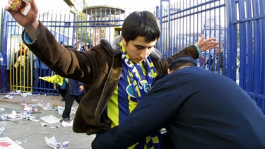 Ein Polizist kontrolliert einen Fan beim Einlass | Bild: picture-alliance/dpa