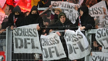 Fans des 1.FC Kaiserslautern halten Plakate mit der Aufschrift "Scheiß DFL" und zünden Feuerwerkskörper im Gästefanblock (7.11.2008). | Bild: picture-alliance/dpa