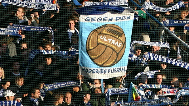 Ein Bochum-Fan hält inmitten des Bochumer Fanblocks ein Plakat mit der Aufschrift "Gegen den modernen Fußball" in die Höhe (24.11.2007) | Bild: picture-alliance/dpa