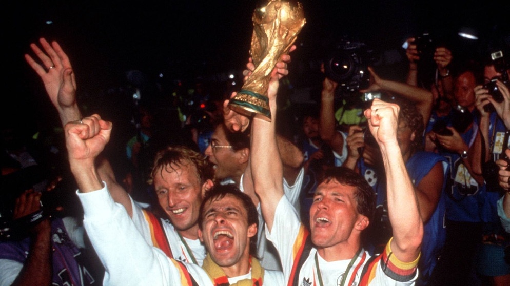 Andreas Brehme, Pierre Littbarski und Lothar Matthäus (v.l.n.r) bejubeln den WM-Sieg. | Bild: imago images