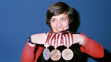 Rosi Mittermaier präsentiert bei einer Pressekonferenz ihre Medaillen, aufgenommen am 15.02.1976 während der Olympischen Winterspiele in Innsbruck | Bild: picture-alliance/dpa