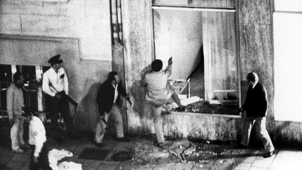 Polizeibeamte dringen unter weiterem Schusswechsel in das Gebäude ein. Ein Banküberfall mit Geiselnahme Anfang August 1971 hat zwei Todesopfer gefordert.  | Bild: picture-alliance/dpa
