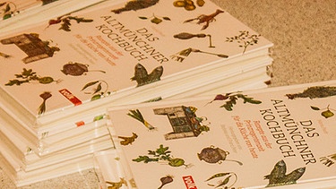 Verkaufstisch "Das Altmünchner Kochbuch" mit mehreren Stapeln des Buches | Bild: BR/Andreas Dirscherl