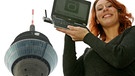 Frau mit DVB-T-Empfangsgerät vor einem Fernsehturm | Bild: picture-alliance/dpa