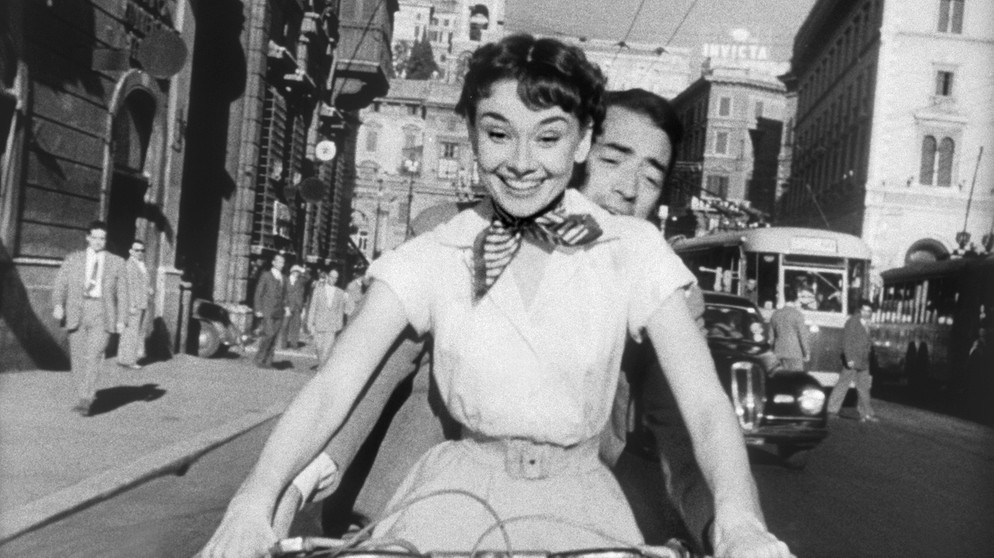 Prinzessin Anne (Audrey Hepburn) verbringt mit Joe Bradley (Gregory Peck) einen aufregend schönen Tag, an dem sie alles tun kann, was normale Menschen tun. | Bild: BR/Telepool GmbH