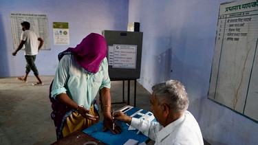 19.04.2024, Indien, Neemrana: Eine Frau bereitet sich auf die Stimmabgabe während des ersten Wahlgangs der indischen Parlamentswahlen in Neemrana im indischen Bundesstaat Rajasthan vor. | Bild: BR