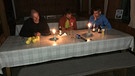 Berglhütte: Gastraum im Kerzenlicht. Christian Mazzag, Josef Plangger und Gerald Holzer (von links) am Vorabend ihrer Tour. Neben dem BR-Kamerateam sind sie die einzigen Gäste auf der Hütte.  | Bild: BR/Kilian Neuwert