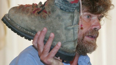 Reinhold Messner im Jahr 2005 mit dem ersten Schuh seines verstorbenen Bruders in Islamabad | Bild: dpa-Bildfunk/Olivier Matthys