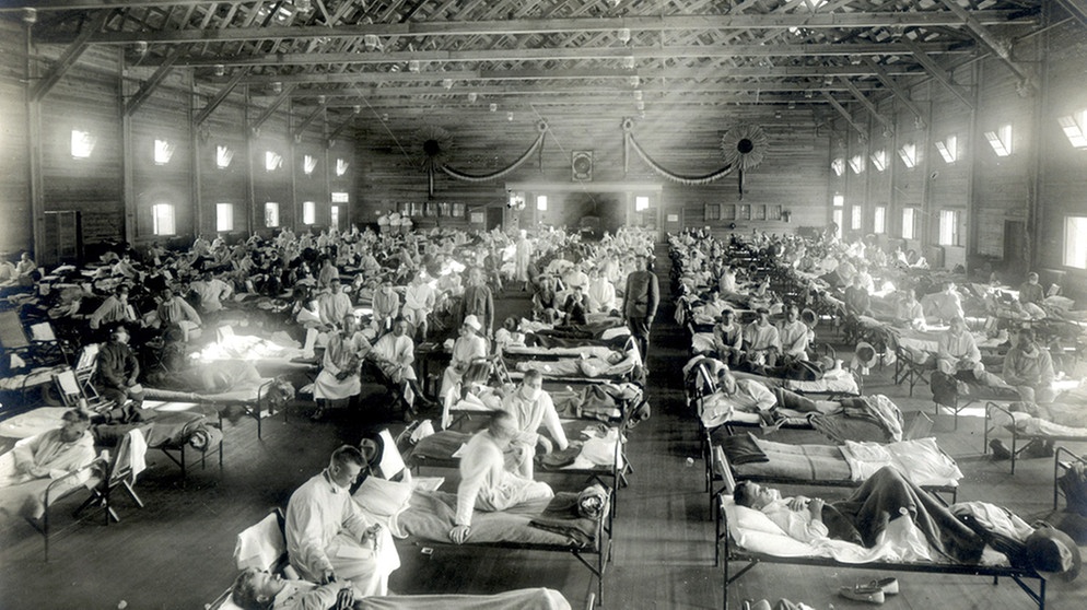 ARCHIV - 01.01.1918, USA, Camp Funston: HANDOUT - Patienten, die an der Spanischen Grippe erkrankt sind, liegen in Betten eines Notfallkrankenhauses im Camp Funston der Militärbasis Fort Riley in Kansas (USA) (Aufnahme von 1918). Die Spanische Grippe entwickelte sich in drei Wellen bis 1920 zur schlimmsten Grippe-Pandemie der Geschichte. In Deutschland starben etwa 300 000 Menschen daran, weltweit 25 bis 40 Millionen. (zu dpa: «2021 versus 1921 - 100 Jahre Deutschland») Foto: -/National Museum of Health and Medicine/dpa - ACHTUNG: Nur zur redaktionellen Verwendung und nur mit vollständiger Nennung des vorstehenden Credits +++ dpa-Bildfunk +++ | Bild: dpa-Bildfunk/-