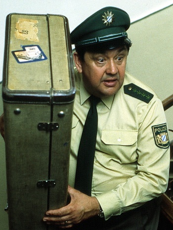 Polizeiinspektion 1-Vorschriftswidrig (128): Moosgruber (Max Griesser) findet im Hausflur einen verdachterregenden Koffer. Woher kommt er? | Bild: BR