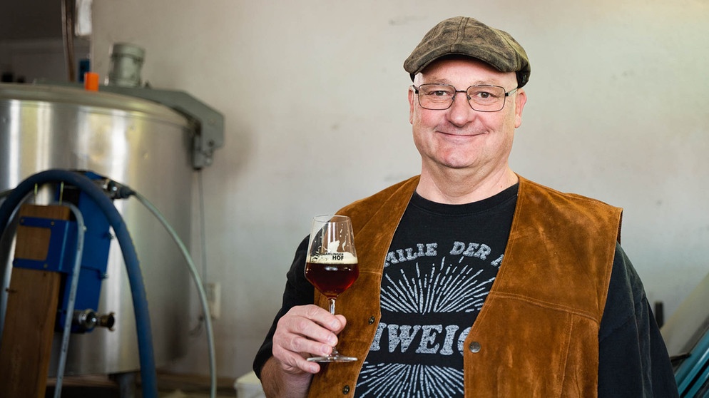 Bernd vor seinem frisch gebrauten Bier. | Bild: BR/Tabea Hofmann