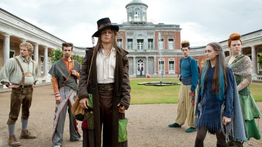 Der verkleidete Jasper (Rafael Gareisen, Mitte) kommt mit seinen fünf Freunden an den königlichen Hof, um eine Wette gegen König Wilbur anzutreten. | Bild: BR/RBB/Daniela Incoronato