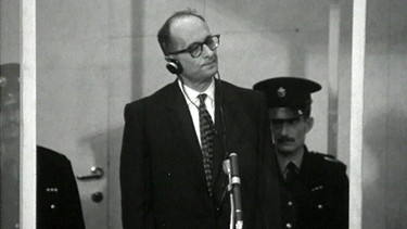 Adolf Eichmann (Mitte) im kugelsicheren Glaskasten mit zwei Polizisten. | Bild: BR