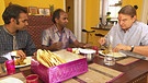 Beim Essen sprechen Nelson Rajendran (Mitte), sein Freund Pankaj Giri (links) und Fritz Häring (rechts) über indische Gepflogenheiten. | Bild: BR/Pierre Angerer
