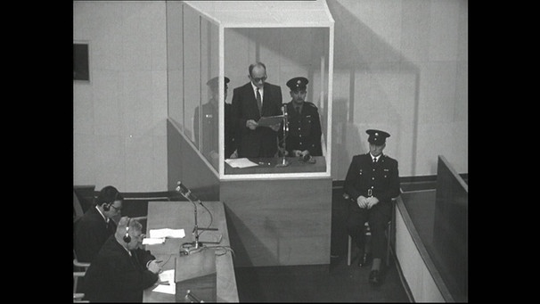 Adolf Eichmann im Glaskasten mit drei Polizisten, Verteidiger Dr. Robert Servatius und sein Assistent (links). | Bild: BR